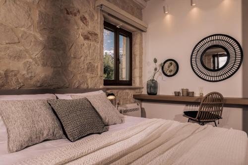 Un dormitorio con una cama, un espejo y una silla. en Mira Agua Villa, en Vasilikos