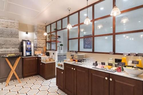 a large kitchen with aasteryasteryasteryasteryasteryasteryasteryasteryasteryasteryastery at Hôtel Silky by HappyCulture in Lyon