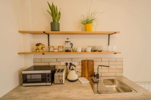 a kitchen counter with a sink and a microwave at Rookery Lane Food and Lodging in Kenmare