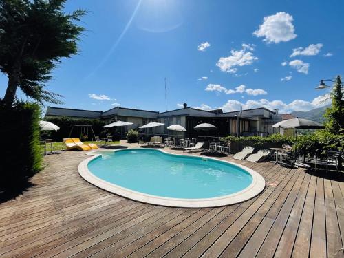 a large swimming pool on a wooden deck at Hotel Villa Cinzia in Villanova Mondovì