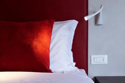 a red and white pillow sitting on top of a bed at All'Orologio - Boutique Hotel in Caorle