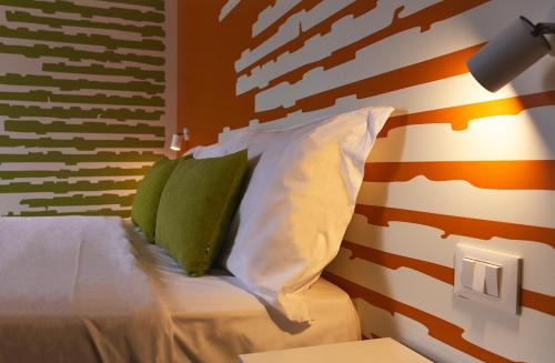 a bedroom with a bed with two pillows at All'Orologio - Boutique Hotel in Caorle
