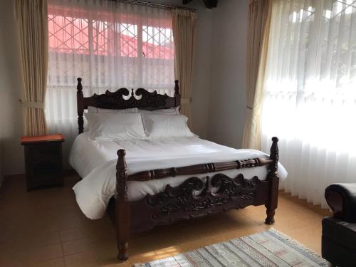 a bedroom with a bed with white sheets and a window at Estancia los pinos in Jenesano