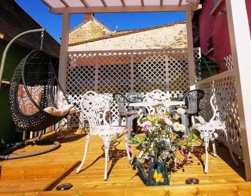 a patio with chairs and a table and a hammock at Le Coin des Artistes in Giverny