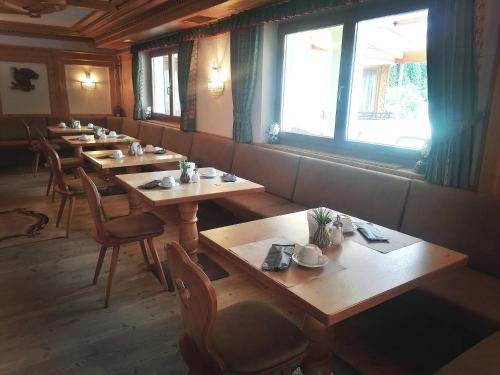 a restaurant with wooden tables and chairs and a window at B&B Bracun in Corvara in Badia