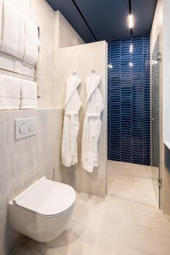 a bathroom with a toilet and a shower with towels at Lion's Castle Hotel in Lviv