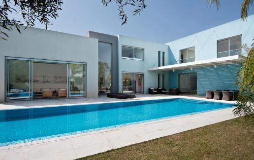 a swimming pool in front of a house at Villa Alice Caesarea in Caesarea