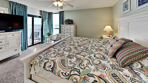 een slaapkamer met een bed en een flatscreen-tv bij Southern Escape on Atlantic Peninsula 2BR Condo in Myrtle Beach