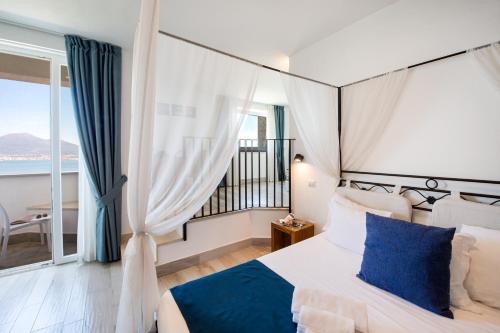 a bedroom with a bed and a large window at Relais Manfredi in Castellammare di Stabia