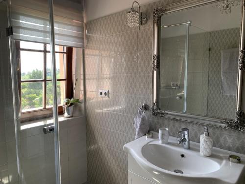 a bathroom with a sink and a shower with a mirror at Villa Garden in Zalaegerszeg