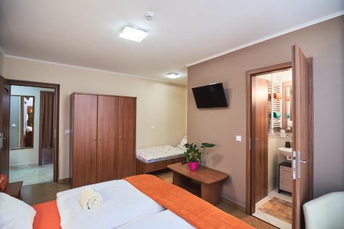 a bedroom with a bed and a television in it at Park-Lak Vendégház in Makó