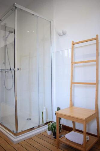 a shower with a glass enclosure and a wooden bench at Playa de Carnota - SondeLira in Lira