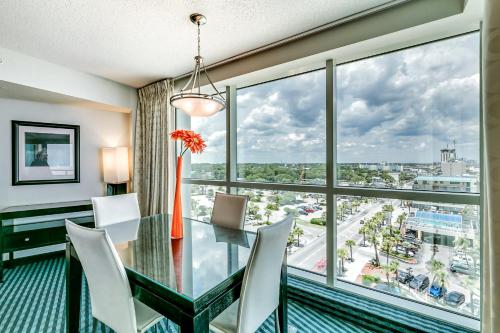 a dining room with a glass table and chairs and a large window at Oceans One Resort in Myrtle Beach