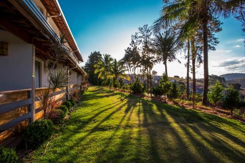 a yard with palm trees and a house at Guarany Eco Resort in Monte Sião
