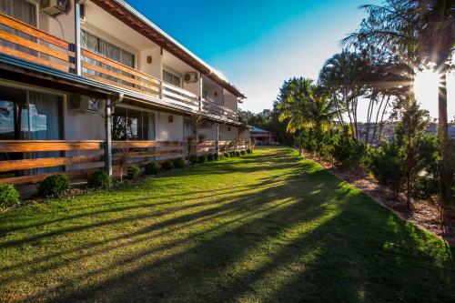 un edificio con el sol brillando en la hierba en Guarany Eco Resort, en Monte Sião