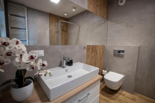 a bathroom with a white sink and a toilet at VIP Apartament in Rzeszów
