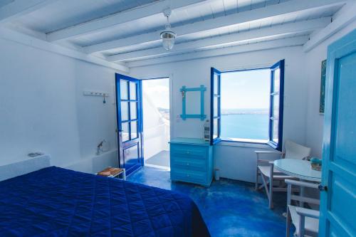 a blue bedroom with a bed and a table at Blue Moon Villa in Imerovigli