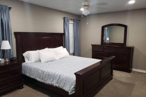 a bedroom with a bed with a mirror and a dresser at Beautiful 3 bedroom 2 Bathroom Home in Temple Medical District in Temple