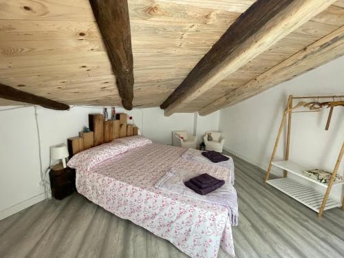 1 dormitorio con 1 cama con techo de madera en El secret de la LLegenda El Cavaller en Vilavert