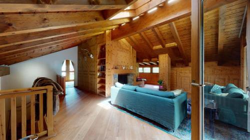 ズルレイにあるChesa Crestaのリビングルーム(青いソファ、木製の天井付)