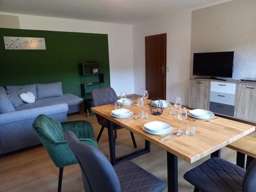 a living room with a wooden table and chairs at Ferienwohnung Mossauer Hoehe in Mossautal