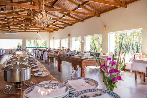 a dining room with tables and chairs and a chandelier at Guarany Eco Resort in Monte Sião