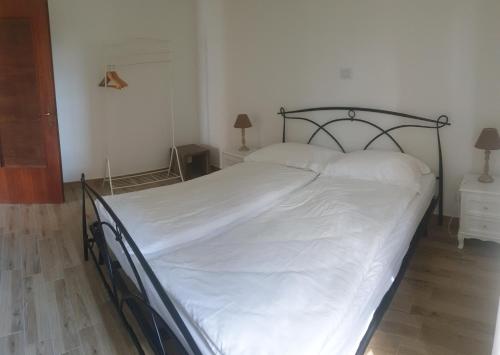 a bedroom with a large bed with white sheets at Appartamento Le Rose in Ossuccio