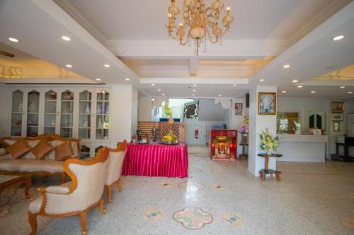 a living room with a chandelier and a red table at Anchalee Resort in Bang Saphan