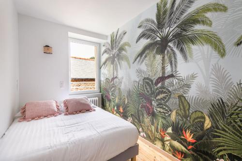 um quarto com um mural de palmeiras na parede em Le Coco - Duplex proche mer em Cancale