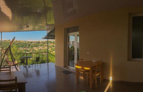 Habitación con mesa, sillas y balcón. en Guest House Maradona en Sighnaghi