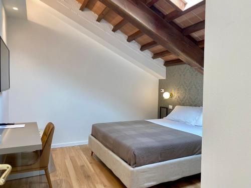 ein Schlafzimmer mit einem Bett und einem Schreibtisch in einem Zimmer in der Unterkunft Residenza d'epoca dei Fondachi in Sarzana