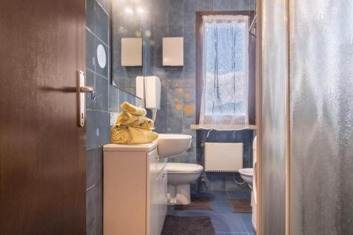 ラヴェーノ・モンベッロにあるHouse Samantha Lago Maggioreのバスルーム(トイレ、シンク、黄色いタオル付)