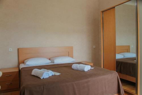 a bedroom with a bed with two towels on it at Guest House Maradona in Sighnaghi