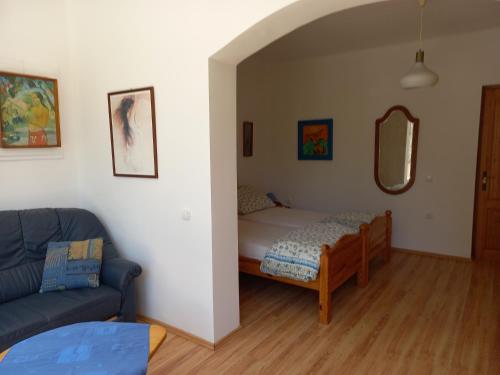 ein Wohnzimmer mit einem Bett und einem Sofa in der Unterkunft Polgár Vendégház in Bük