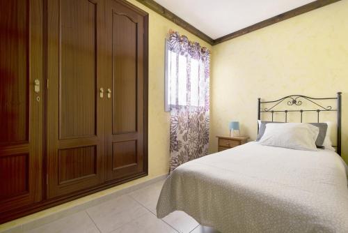 a bedroom with a bed and a closet and a window at Apartamento Vistas de Icod in Icod de los Vinos