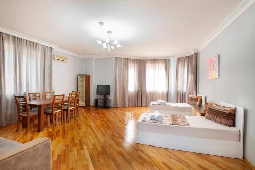 a living room with a couch and a table and chairs at Leyla Apartments 1 in Baku