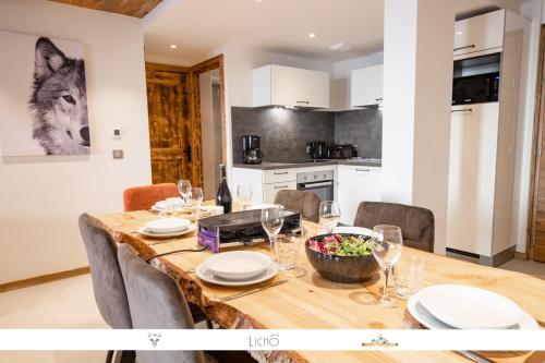 a kitchen and dining room with a wooden table and chairs at MARMOTTE 101 - Appartement pour 6, aux pieds des pistes in Bonneval-sur-Arc