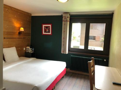 a bedroom with two beds and a window at Le Saint Antoine in Les Houches