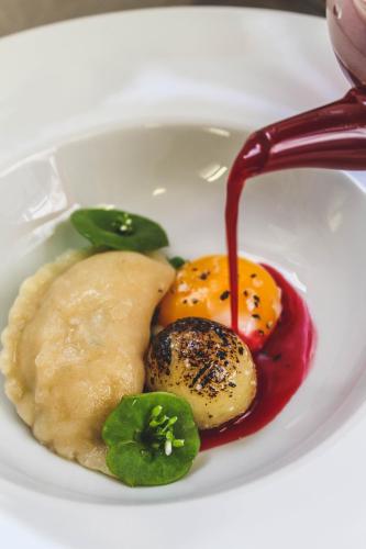 a white plate of food with sauce and vegetables at Bunratty Manor Hotel in Bunratty