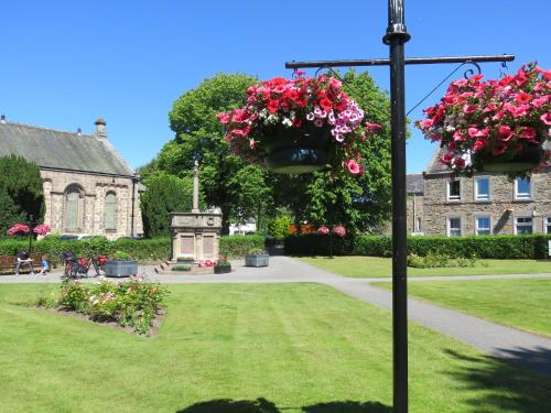 a garden with flowers hanging from a light pole at Bankhouse B&B in Aberlour