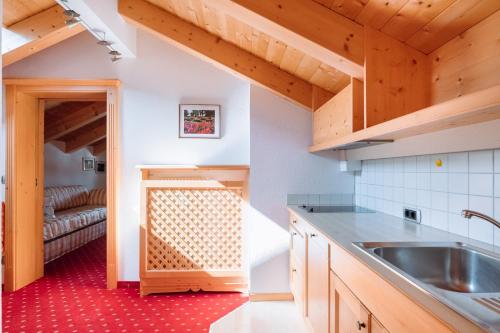 eine Küche mit einem Waschbecken und einem Sofa in der Unterkunft Residence Alpenrose in Rasùn di Sotto