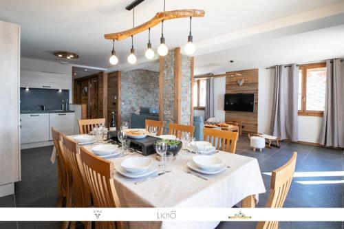 a dining room and kitchen with a table and chairs at MARMOTTE 102 - Beau T4 pour 10, aux pieds des pistes in Bonneval-sur-Arc