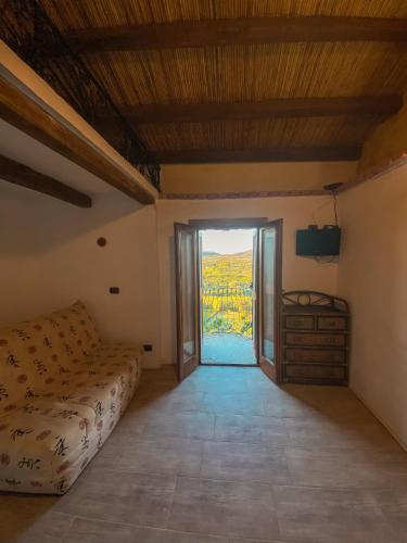 a room with a bed and a sliding glass door at BILOCALE CON VISTA MARE E TERRAZZA PANORAMICA Ammentos Posada in Posada