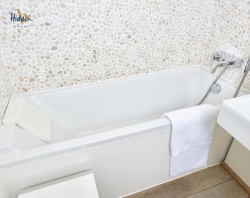 a bathroom with a white bath tub next to a sink at Hidden Bay Hotel in Cayeux-sur-Mer