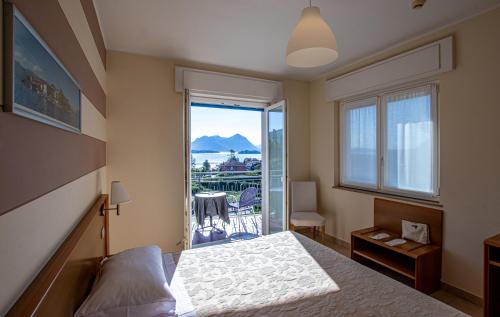 een slaapkamer met een bed en uitzicht op de oceaan bij Hotel Alpi in Baveno