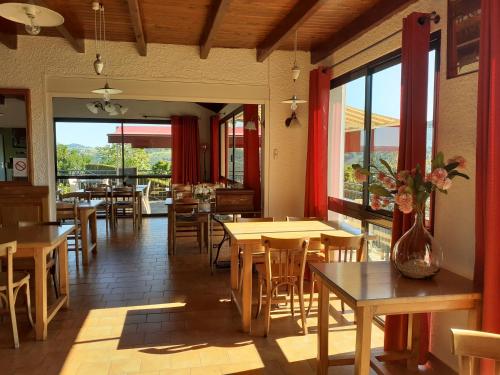 un restaurant avec des tables et des chaises en bois et des fenêtres dans l'établissement le belvedere de mallet, à Sarrus