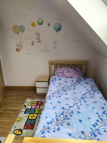 a bedroom with a bed with planets on the wall at Kaszubska Zagroda in Lipuska Huta