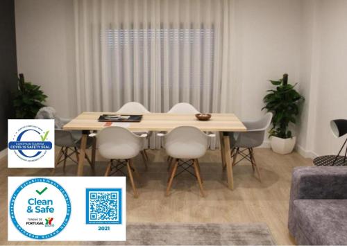 a dining room with a table and white chairs at Holiday Cascais Apartment in Cascais