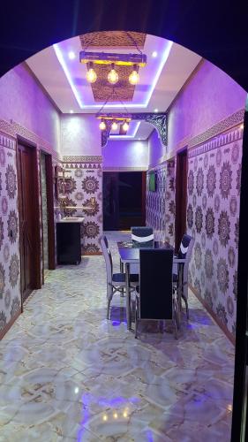 a dining room with a table and chairs and purple lighting at Villa Salah in Marrakech