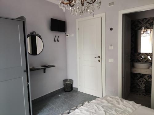 a bedroom with a bed and a mirror and a chandelier at A Cantunera LittleHouse in Agrigento